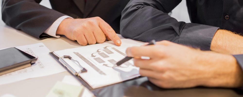 close-up-two-businessmen-pointing-business-chart-meeting